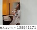 Cheerful woman in pajamas holding glass of coffee 138941171