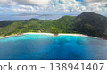 Turquoise waters meeting tropical green hills on a sunny coastline. La Digue, Seychelles. 138941407