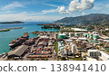 Large shipping containers and storage tanks located by the harbor, with green islands and turquoise waters in the background. Victoria. Seychelles, Mahe. 138941410