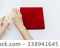 The scene of untying the white ribbon from a red gift box. 138941645