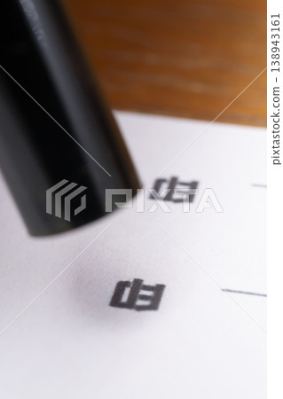 一隻手正在往印章上塗抹紅墨。 一隻手正在往印章上塗抹紅墨。 138943161