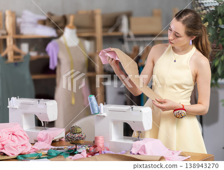 Young woman seamstress with pattern in sewing workshop 138943270