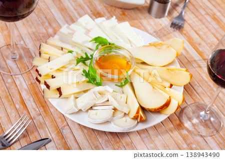 Cheese plate served with honey on wooden table 138943490