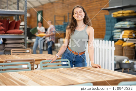 Interested young female shopper looking for outdoor table in store 138943522