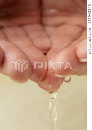 用雙手從洗臉盆裡舀水。 用雙手從洗臉盆裡舀水。 138943540