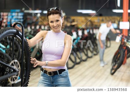 Adult woman choosing bike in store 138943568