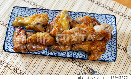 Alitas de pollo con patata, chicken wings with potato on a ceramic plate in restaurant Alitas de pollo con patata, chicken wings with potato on a ceramic plate in restaurant 138943572