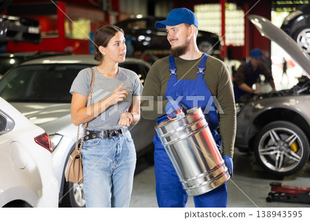 Young male mechanic giving gasoline to female customer Young male mechanic giving gasoline to female customer 138943595