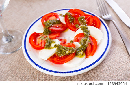 Caprese salad with mozzarella, tomatoes and pesto sauce on plate Caprese salad with mozzarella, tomatoes and pesto sauce on plate 138943634