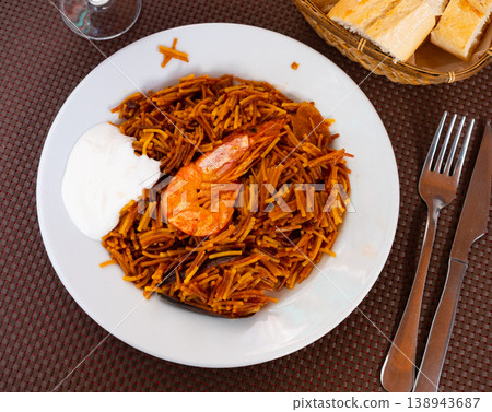 Traditional spanish seafood dish fideua with aioli sauce in restaurant 138943687