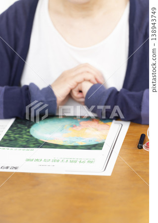 一位老婦人正在簽署並蓋章她的海外旅行保險合約。 一位老婦人正在簽署並蓋章她的海外旅行保險合約。 138943749