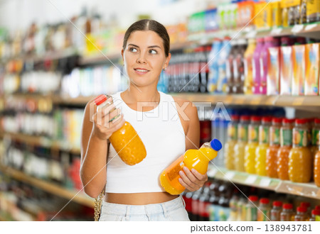 Girl in supermarket buys bottle of soda drink Girl in supermarket buys bottle of soda drink 138943781