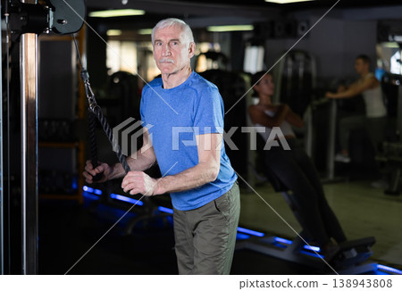 Elderly man training with straps in gym Elderly man training with straps in gym 138943808