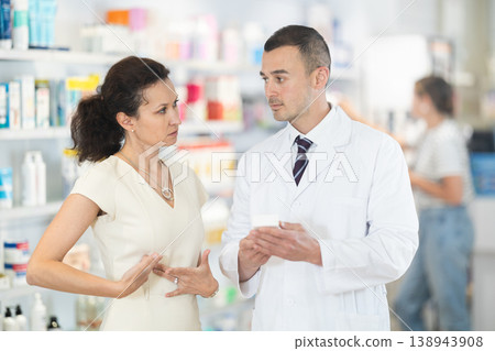 Male pharmacist advises medicine for heart pain to woman 138943908