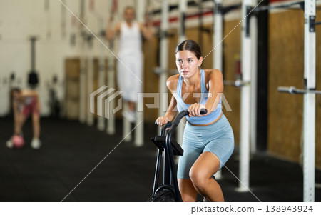 Young woman exercising on exercise bike in gym 138943924