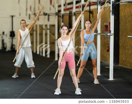 Young woman doing warm-up with stick 138943933