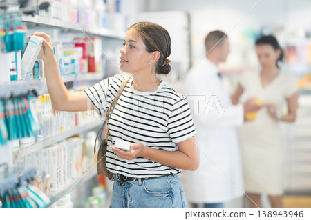 Young woman choosing medicine at pharmacy 138943946