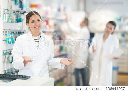 Attentive female pharmacist looking at computer in chemist shop with large assortment Attentive female pharmacist looking at computer in chemist shop with large assortment 138943957