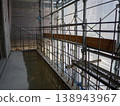 Safety scaffolding and mesh sheets at a construction site; rebar installation work in progress. 138943967