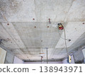 A demolition site in a skeletal state, with exposed concrete ceilings and electrical wiring. 138943971