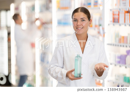 Girl pharmacist holds out bottle cosmetic 138943987