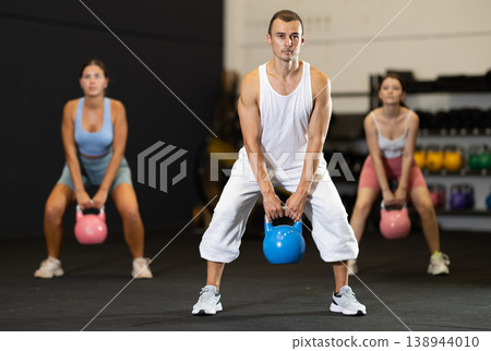 Young man training with kettlebell in gym 138944010