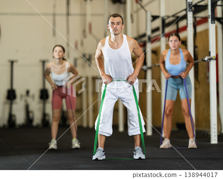Young man exercising with elastic band Young man exercising with elastic band 138944017