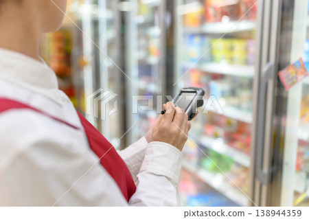 店員掃描商品條碼。 店員掃描商品條碼。 138944359