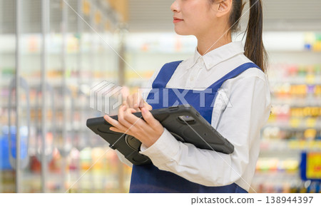 女店員操作平板電腦時，鏡頭特寫她的臉。 138944397