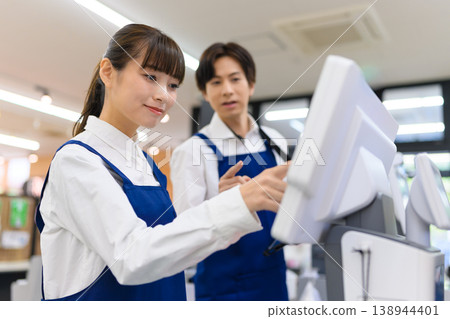 一位教導顧客如何使用收銀機的店員 138944401