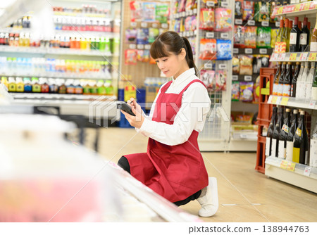 Female shop assistant checking the merchandise 138944763