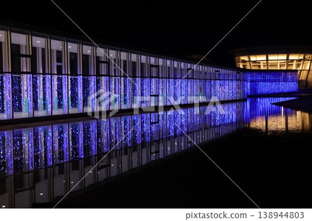 藍色的燈光照亮了建築物,夜景倒映在水面上。 藍色的燈光照亮了建築物,夜景倒映在水面上。 138944803