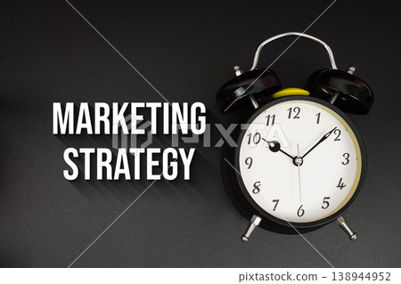 Marketing Strategy text with alarm clock on black background Marketing Strategy text with alarm clock on black background 138944952