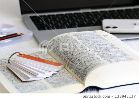 A scene of dictionaries and study materials spread out on a study desk. A scene of dictionaries and study materials spread out on a study desk. 138945137