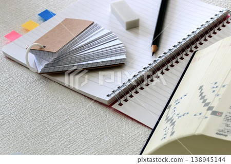 A photograph of a notebook, dictionary, and stationery representing time spent learning. 138945144