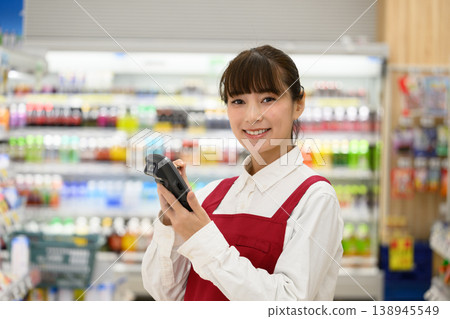 A smiling female shop assistant holding a tablet 138945549