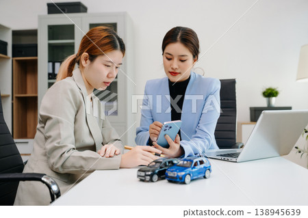 Car insurance consultation using smartphone and documents. Advisor and customer reviewing digital insurance service, auto policy, finance, technology Car insurance consultation using smartphone and documents. Advisor and customer reviewing digital insurance service, auto policy, finance, technology 138945639