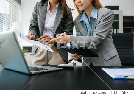 Business documents on office table with smart phone and calculator digital tablet and graph business with social network diagram and two colleagues discussing data Business documents on office table with smart phone and calculator digital tablet and graph business with social network diagram and two colleagues discussing data 138945683
