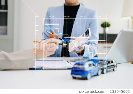 Professionals reviewing a car accident claim with model vehicles, illustrating auto insurance, risk assessment, and financial consultation in office 138945693