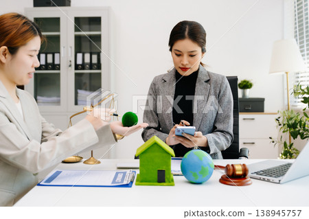 A lawyer presenting a green house model and earth globe with a gavel showing environmental law eco policy sustainability justice and global A lawyer presenting a green house model and earth globe with a gavel showing environmental law eco policy sustainability justice and global 138945757