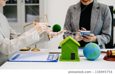 A lawyer presenting a green house model and earth globe with a gavel showing environmental law eco policy sustainability justice and global A lawyer presenting a green house model and earth globe with a gavel showing environmental law eco policy sustainability justice and global 138945758