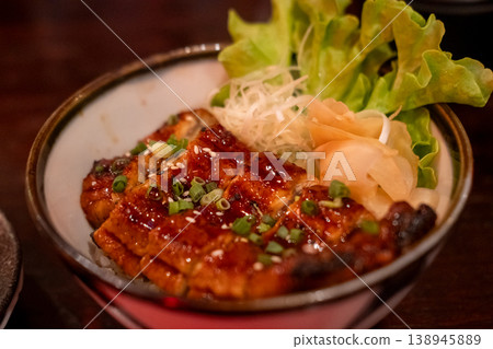 Unagi don. Grilled eel with sweet sauce rice bowl on wooden table. Unagi don. Grilled eel with sweet sauce rice bowl on wooden table. 138945889