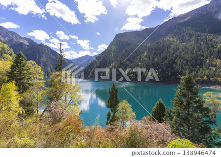Beautiful view of the Long Lake among colorful fall woods and mountains in Jiuzhai Valley National Park in China. Beautiful view of the Long Lake among colorful fall woods and mountains in Jiuzhai Valley National Park in China. 138946474