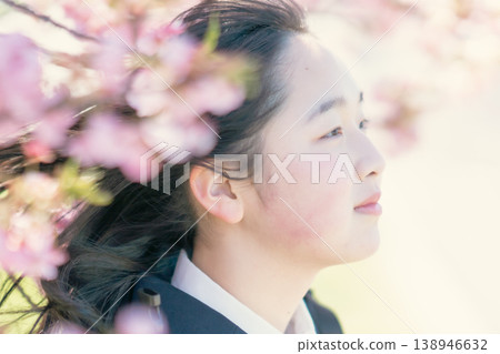 一位女學生凝視遠方，背景是盛開的櫻花樹。春日人像。美麗影像。 138946632
