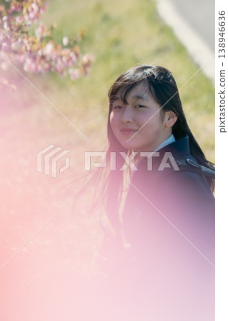 A portrait of a female student walking to school under cherry blossoms, wearing a blazer. A portrait of a female student walking to school under cherry blossoms, wearing a blazer. 138946636