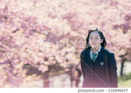 A portrait of a female student walking to school under cherry blossoms, wearing a blazer. A portrait of a female student walking to school under cherry blossoms, wearing a blazer. 138946637