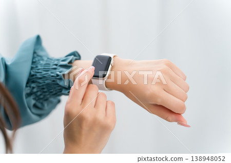A woman's hand operating a smartwatch A woman's hand operating a smartwatch 138948052