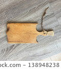 Wooden cutting board placed on a light wooden surface showing texture and design in a kitchen setting during the daytime 138948238