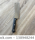 Sharp kitchen knife laying on wooden surface near cutting area 138948244