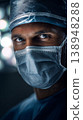 Surgeon looks towards the camera while wearing a mask in a bright operating room during a surgical procedure 138948288